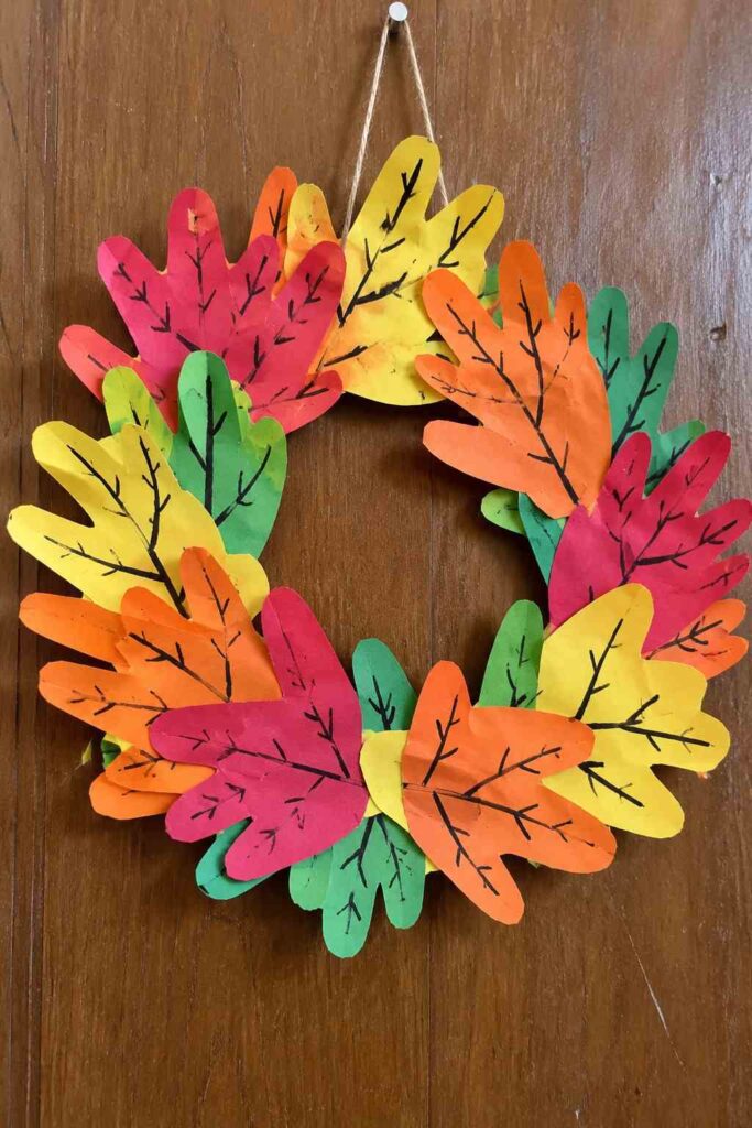 21 Easy & Creative Fall Crafts for Kids to Make at Home 22 20. Colorful Paper Handprint Fall Wreath Make a cheerful fall wreath using colorful paper handprints! This easy craft turns simple construction paper into a bright autumn decoration that kids can help create for the front door or classroom. Materials Needed: - Red, orange, yellow, and green construction paper - Black marker - Cardboard - Glue stick - Child-safe scissors - String or ribbon How to Make It: 1. Trace your child's hand on different colored papers and cut out several handprints. 2. Draw simple branch-like lines on each handprint using a black marker. 3. Cut a large cardboard ring and glue the handprints around it, overlapping them slightly. 4. Add more paper hands to fill empty spaces and create a colorful wreath. 5. Attach a small piece of string at the top for hanging. Quick Tip: Mix large and small handprints, and don't worry if the shapes overlap unevenly. That's what gives the wreath its handmade charm!