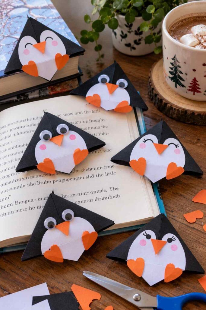 20 Easy Winter Paper Crafts to Make at Home (Fun & Simple Ideas) 10 ## 8. Origami Penguin Corner Bookmarks These cute penguin bookmarks are easy to make with paper and are perfect for little readers on chilly winter days. **Materials** - Black, white, and orange construction paper - Scissors and glue - Black marker **How to Make Them** 1. Fold a square piece of black paper into a corner bookmark. 2. Cut a white oval or heart-shaped piece for the penguin’s belly. 3. Glue it onto the front of the folded corner. 4. Add two small eyes and an orange paper beak. 5. Cut tiny orange feet and glue them near the bottom. **Tip:** Make a few penguins with different expressions to create a fun set of winter bookmarks.