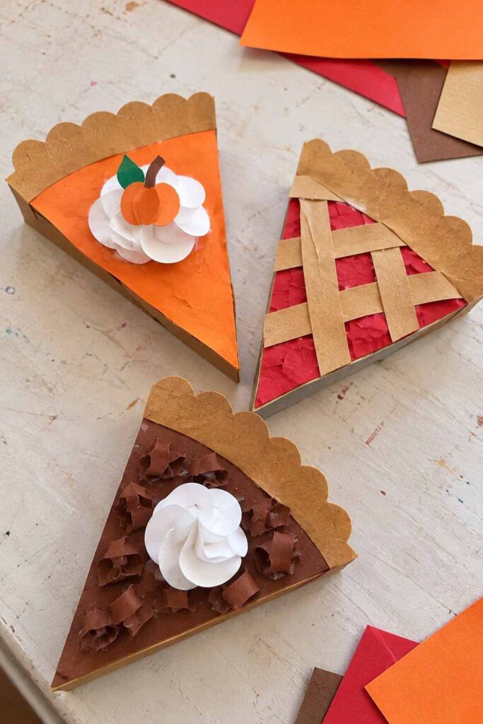 21 Easy & Creative Fall Crafts for Kids to Make at Home 8 6. Easy Paper Pie Craft for Kids Bring the cozy feeling of fall baking to craft time with these cute paper pie slices. Kids can use construction paper and recycled cardboard to create pumpkin pie, cherry pie, and chocolate pie. This simple Thanksgiving craft is great for preschoolers, kindergarteners, and autumn classroom activities. Materials Needed: - Brown construction paper or thin recycled cardboard - Orange, red, and dark brown paper - White paper for the whipped cream - Green paper for a small leaf - Glue stick - Child-safe scissors How to Make It: 1. Cut a large triangle from cardboard or brown paper to make the pie slice. 2. Cover the triangle with orange paper for pumpkin pie, red paper for cherry pie, or dark brown paper for chocolate pie. 3. Cut a few thin strips of brown paper and glue them across the red slice to make a simple lattice crust. 4. Tear or cut small pieces of colored paper and glue them onto the pie filling for texture. 5. Roll or layer small pieces of white paper to make whipped cream. Add a tiny paper pumpkin or leaf if desired. Quick Tip: Let kids create just one flavor each, then display all the paper pies together for a colorful fall dessert collection.